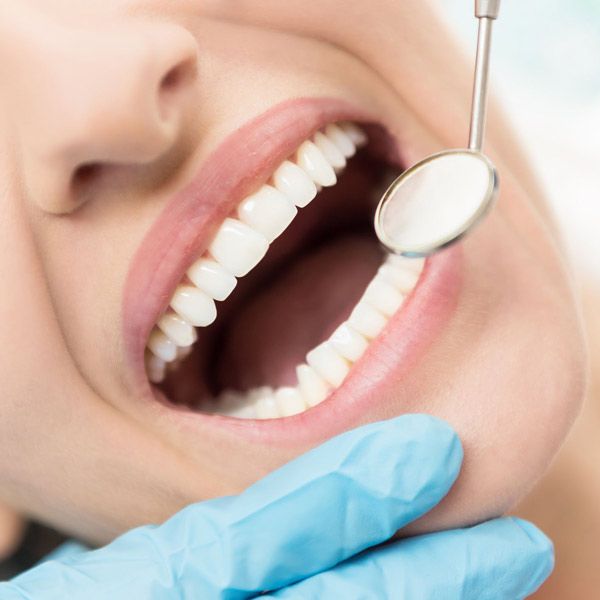 Dental mirror next to patient's teeth