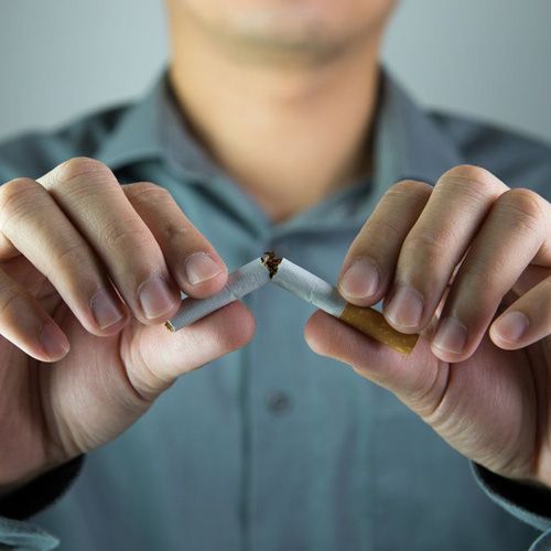 Man breaking cigarette in half